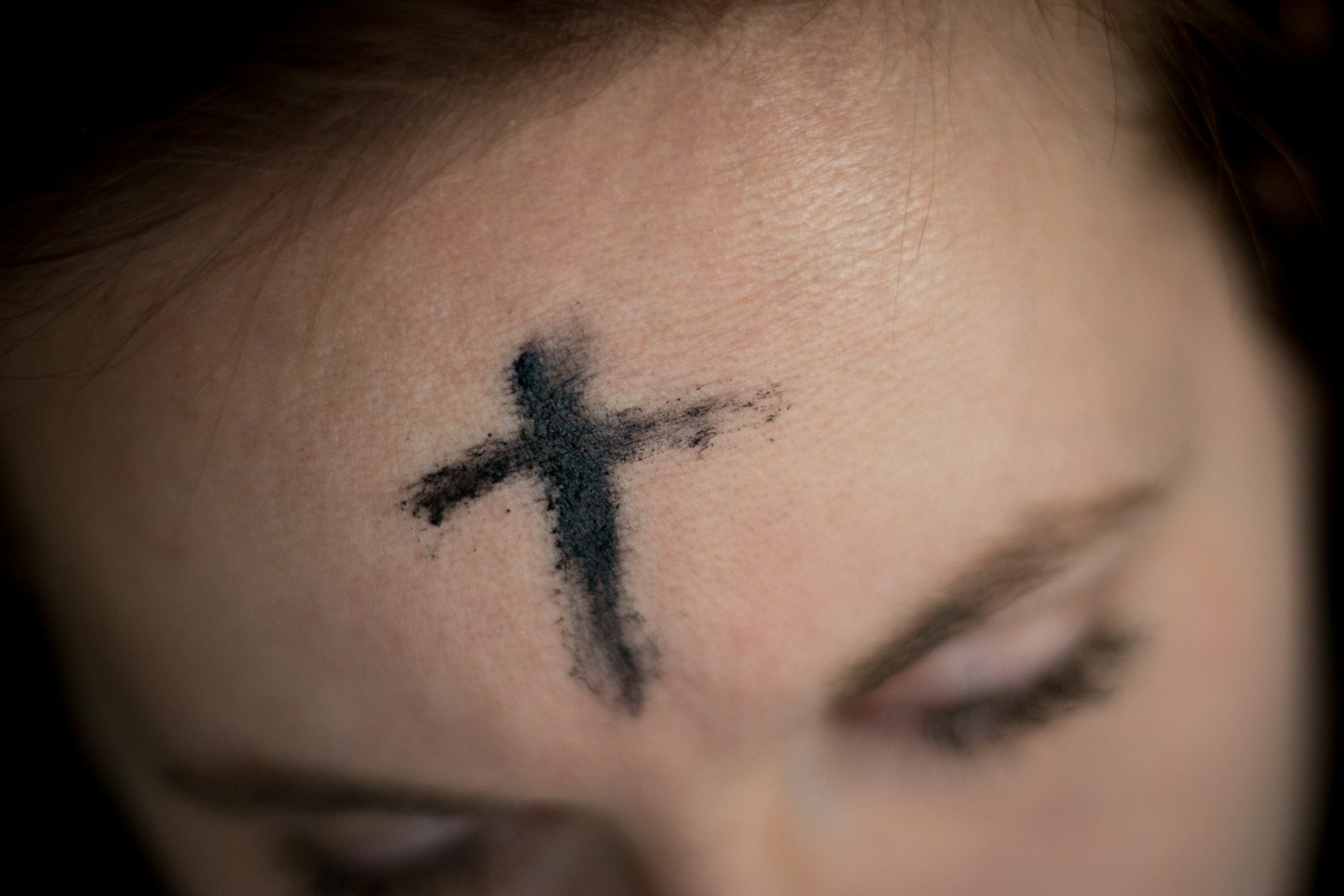 black cross on person's forehead
